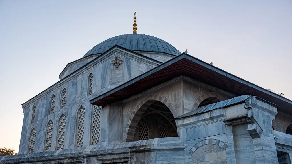 Sultan Ahmed Türbesi'nin mermer cephesi; silmelerle bölünmüş duvarlar, iki sıra pencere, kubbe kasnağı, tepede alem ve önde eğimli revak çatısı.