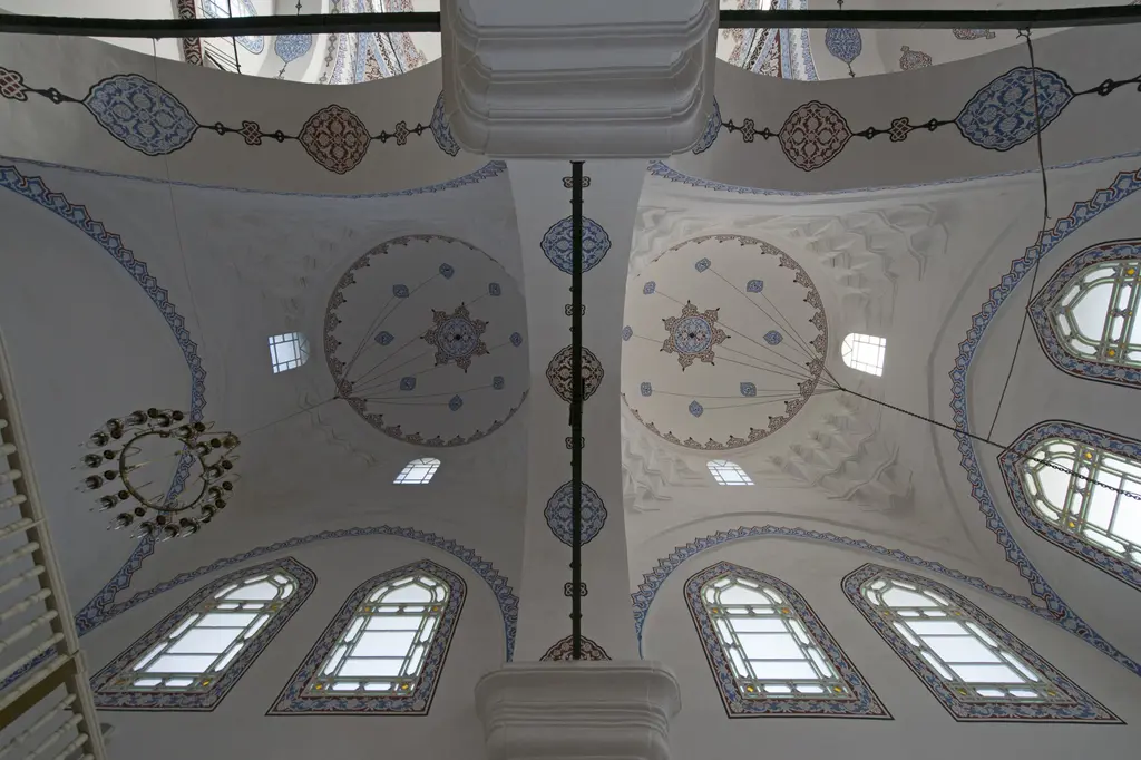 Gazi Atik Ali Paşa Camii'nin yan bölmesinde iki kubbe; kalem işi göbekler, sivri kemerli pencereler, halka avize ve beyaz sıva.