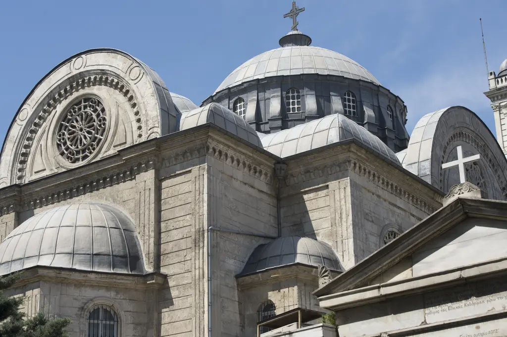 Aya Triada Kilisesi'nin üst örtüsü; merkezî kubbe, çevresinde yarım kubbeler, alınlıkta gül pencere ve tepede haç.
