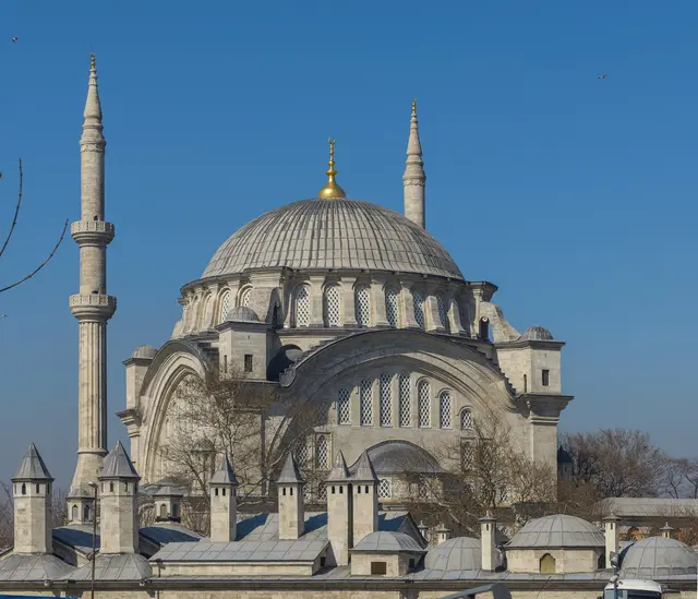 Fatih'te Nuruosmaniye Camii; tek büyük kurşun kubbe, iki ince minare, kubbenin altını dolduran dev kemerli pencere duvarı ve önde külliyenin küçük kubbeleri.