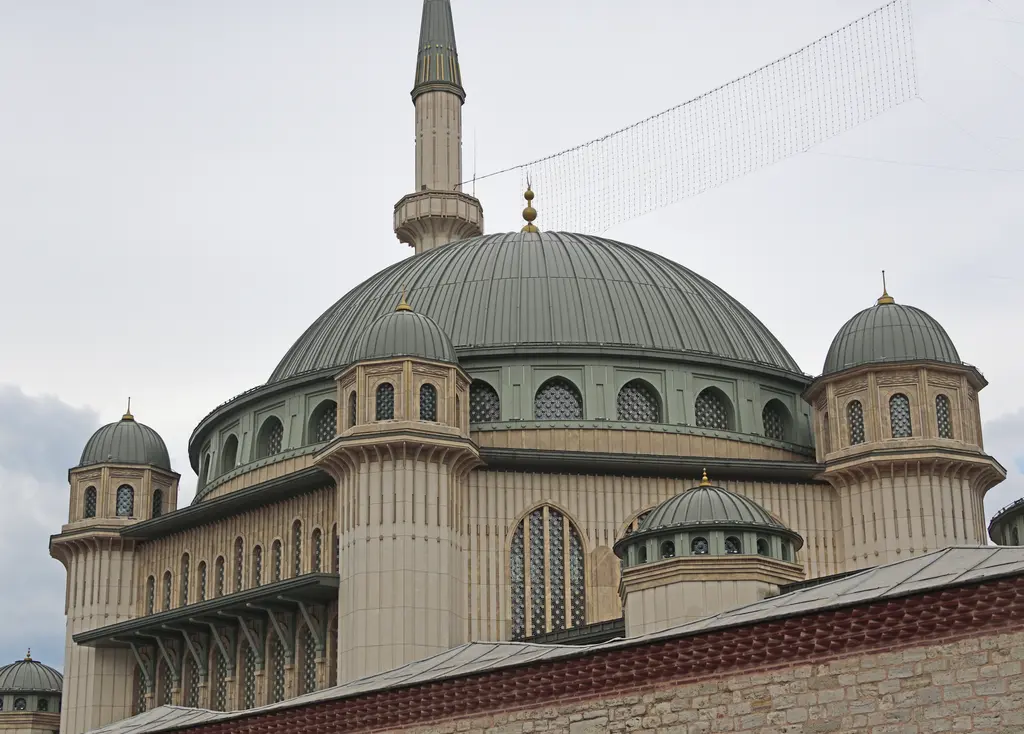 Taksim Camii'nin kubbeleri; gri metal kaplı merkezî kubbe, kasnağındaki pencere dizisi ve çevresinde kademelenen küçük kubbeler.
