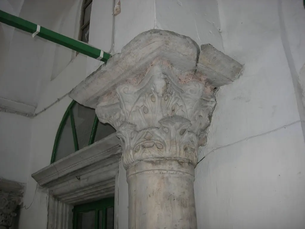 Vefa Kilise Camii'nde camekânla kapatılmış narteksin içinde bir başlık; iki sıra akantus yaprağı, köşelerde volütler, üstte kırık impost levhası ve badanalı duvarlar.