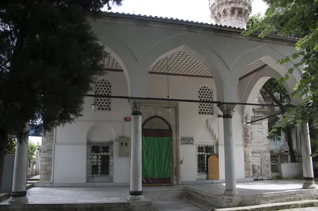 Eyüp'te Defterdar Camii; kesme taş duvarlı dikdörtgen yapı, sütunlu son cemaat yeri, yeşil kapı ve sağda minare.