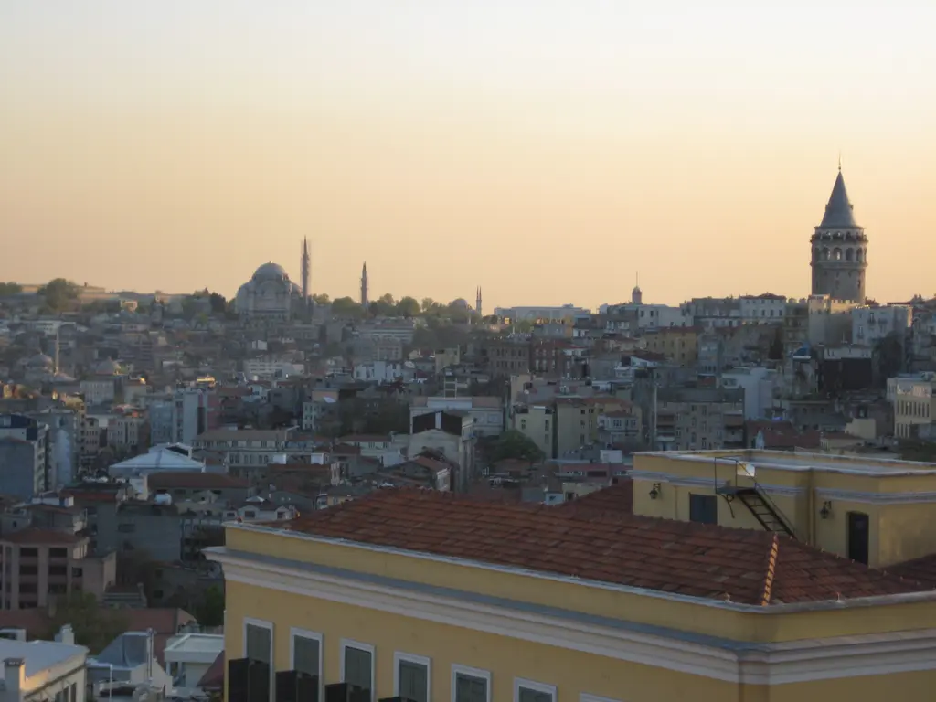 Cihangir yamacından batıya bakış; önde sarı cepheli bina ve kiremit çatı, ufukta Galata Kulesi ve Süleymaniye Camii.