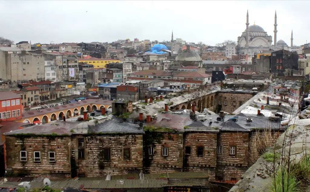 Büyük Yeni Han yukarıdan; uzun dikdörtgen avlu, sıra sıra kemer dizileri, arkada Haliç'e inen yamaç ve bir selâtin camisinin silueti.