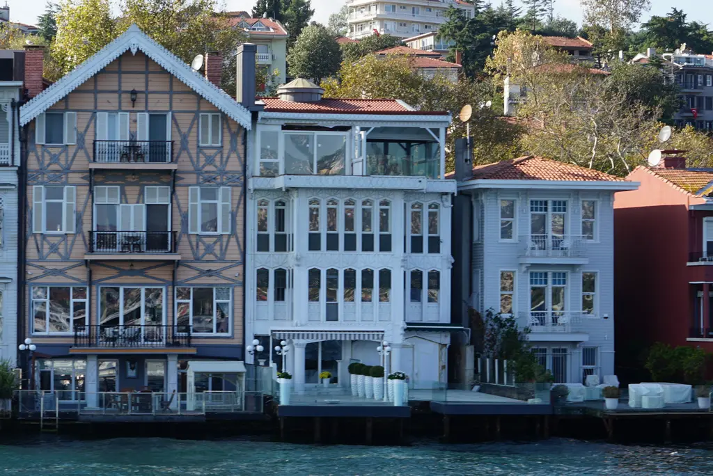 Kosti Rozi Yalısı; ahşap kafesli sivri çatılı cephe, yanında beyaz ve açık mavi yalılar ve önde rıhtım.