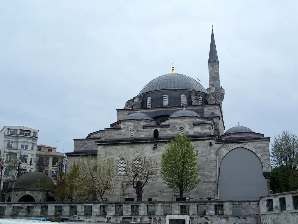 Çemberlitaş'ta Gazi Atik Ali Paşa Camii; kesme taştan gövde, kurşun kaplı büyük kubbe, yan kubbeler, sivri külahlı minare ve önde ağaçlar.