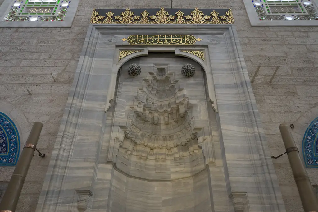 Yavuz Sultan Selim Camii'nin mihrabı; mermer niş, kademeli mukarnas kavsara, üstte altın yaldızlı hat kitabesi ve iki yanda çini şeritler.
