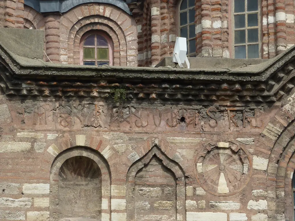 Fethiye Camii'nin cephesinde duvar detayı; dönüşümlü tuğla ve kesme taş sıraları, profilli taş korniş ve korniş üzerinde kazınmış Yunanca kitabe.