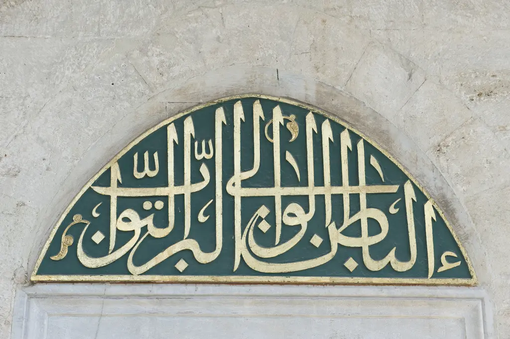 Nişancı Mehmed Paşa Camii'nde pencere alınlığında yeşil zemin üzerine yaldızlı harflerle yazılmış hilal biçimli hat levhası.