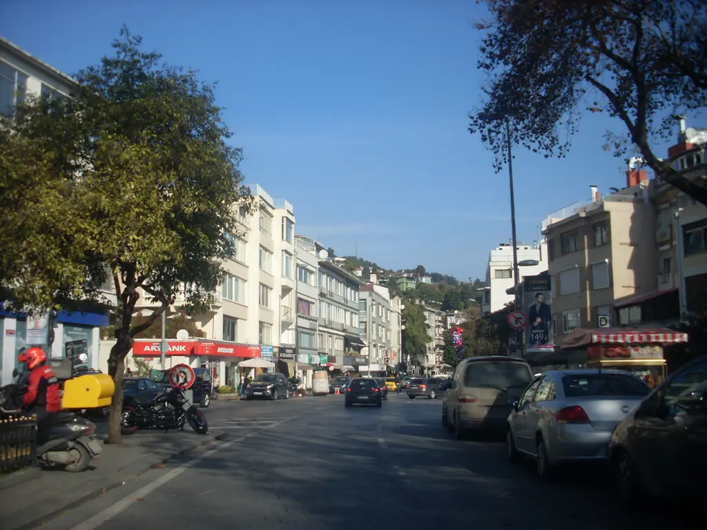 Bebek'te Cevdet Paşa Caddesi; iki yanda apartmanlar, dükkânlar, banka tabelası, park etmiş araçlar ve ağaçlar.