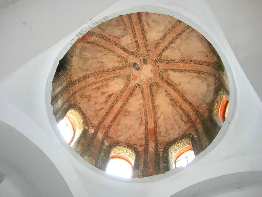 Vefa Kilise Camii'nde dış narteksin küçük kubbelerinden birine dik yukarı bakış; tepede birleşen sekiz kırmızı tuğla kaburga, eski sıva izleri ve eteğinde dört kemerli pencere.