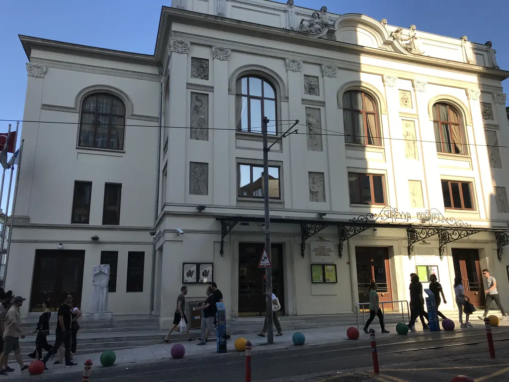 Süreyya Operası'nın cephesi; yuvarlak kemerli üst kat pencereleri, kabartmalı paneller ve gölgeli giriş katı.