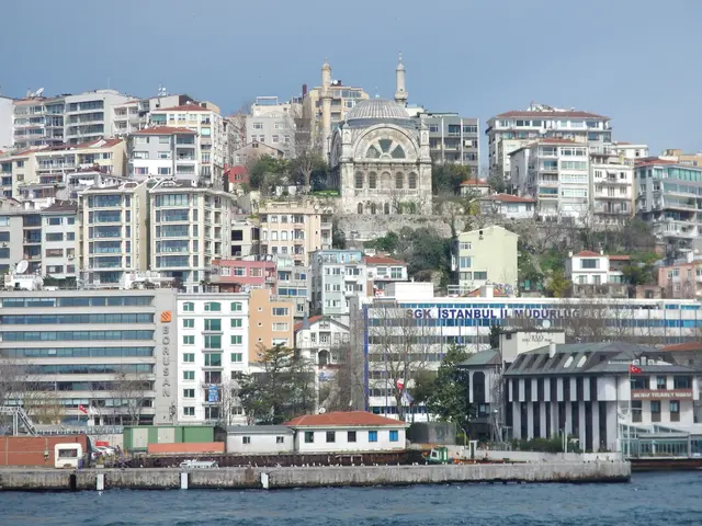 Cihangir'e Boğaz'dan bakış; yamaçta sık apartmanlar, ortada iki minareli kubbeli cami ve kıyıda ofis binaları.