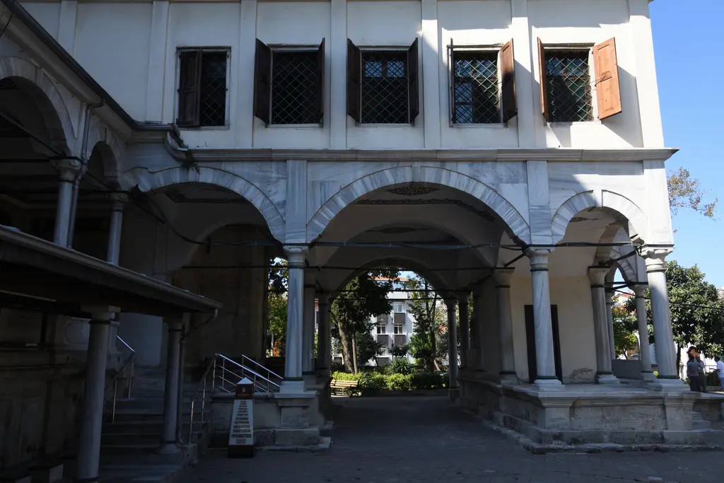 Selimiye Camii'nde hünkâr kasrının altı; sütunlu kemerli geçit, üstte pencereli beyaz kat ve arkada avlu.