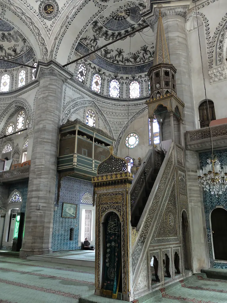 Mermer minber; yuvarlak kemerli kapı, ajurlu bitkisel taç, yanlarda dilimli kemerli açıklıklar ve üstte ahşap külah.