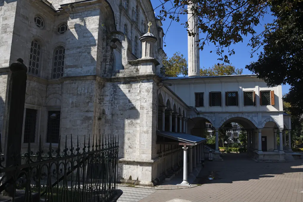 Selimiye Camii'nin yan cephesi; demir parmaklık, taş gövde, saçaklı revak ve arkada beyaz hünkâr kasrı.