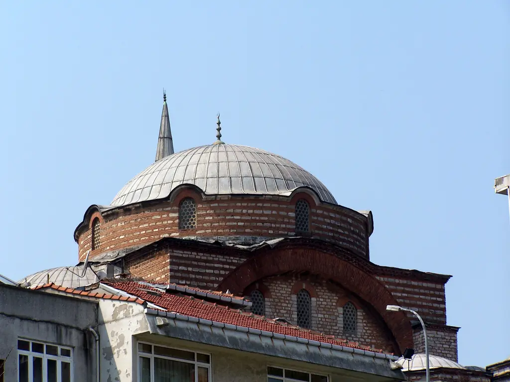 Rum Mehmed Paşa Camii'nin kubbesi; tuğla kasnak, kemerli pencereler, kurşun kaplı kubbe ve önünde kiremit çatılar.