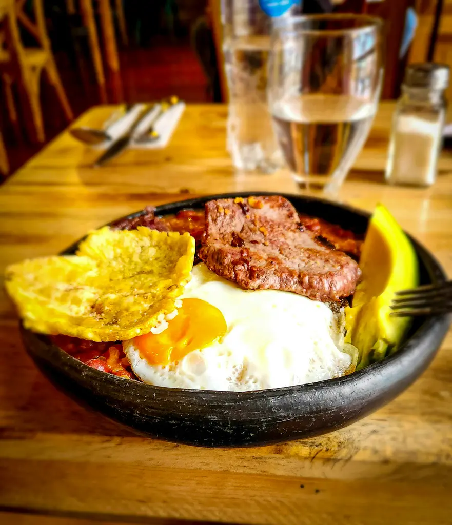 Kolombiya mutfağından bir tabak; mısır unundan yapılmış arepa, yanında fasulye, et ve muz dilimleri.
