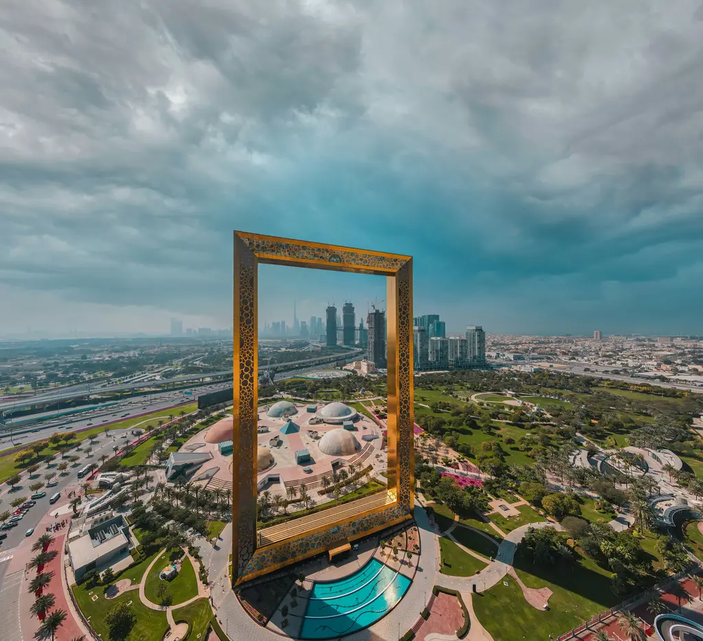 Dubai Frame (Dubai Çerçevesi); dev altın renkli dikdörtgen çerçeve yapı ve arkasındaki şehir.