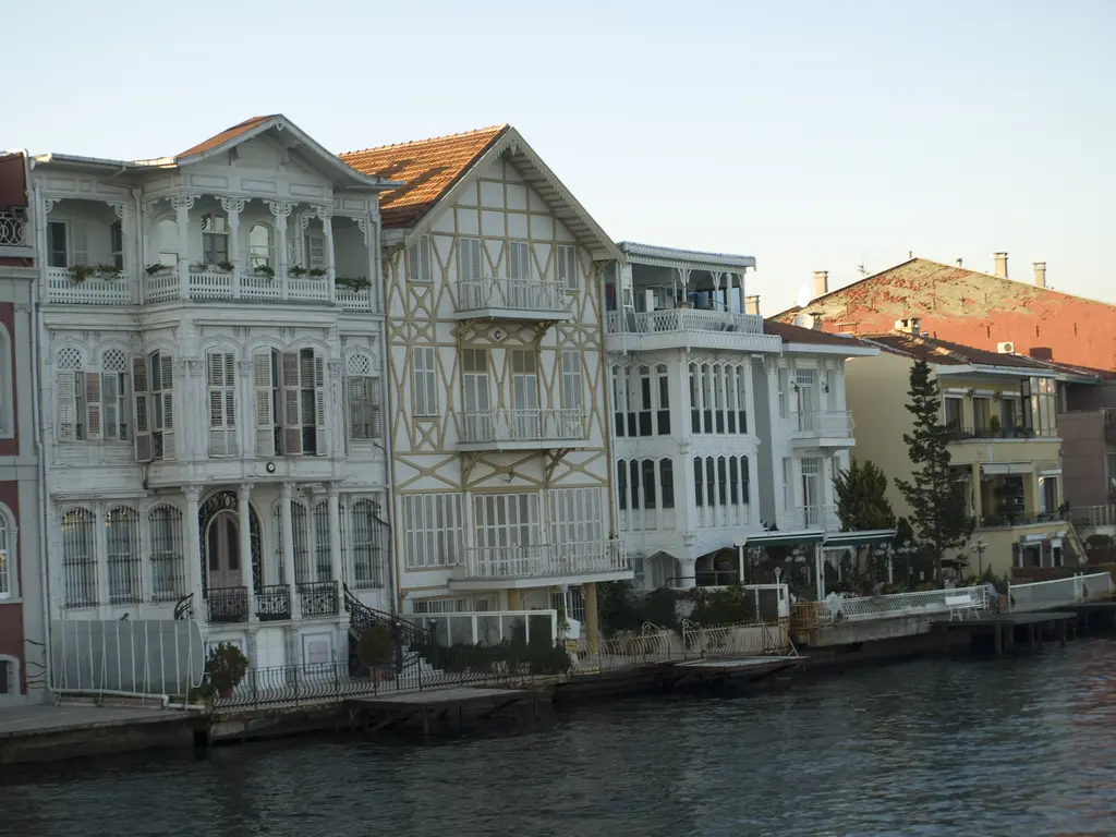 Yeniköy kıyısında yan yana yalılar; oymalı ahşap cepheler, kafes süslemeli bir yalı ve önde rıhtım ile su.