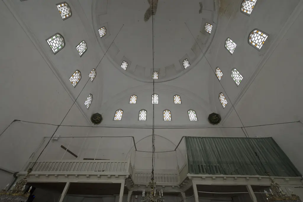Rum Mehmed Paşa Camii'nde giriş tarafı; iki yanda ahşap korkuluklu mahfiller, pencereler ve tavandan sarkan avize.