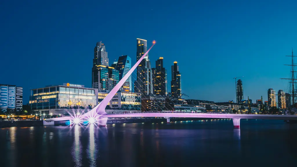 Buenos Aires'te Puerto Madero; rıhtım boyunca cam gökdelenler, eski tuğla depolar ve su üzerindeki köprü.