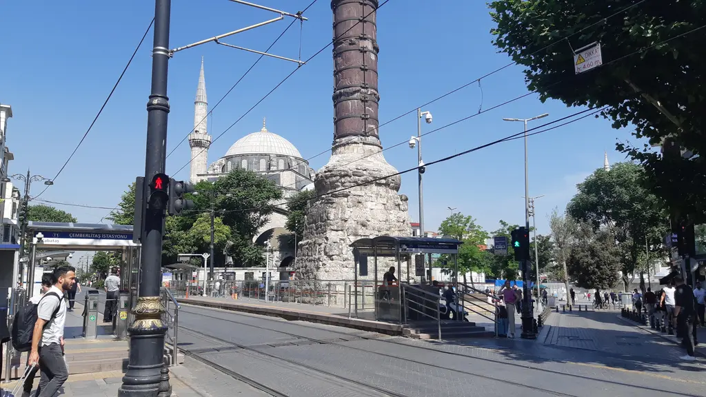 Çemberlitaş'ta tramvay hattı ve sütun; raylar, üstteki katener telleri, sağda sütun, solda cami kubbesi ile minare.