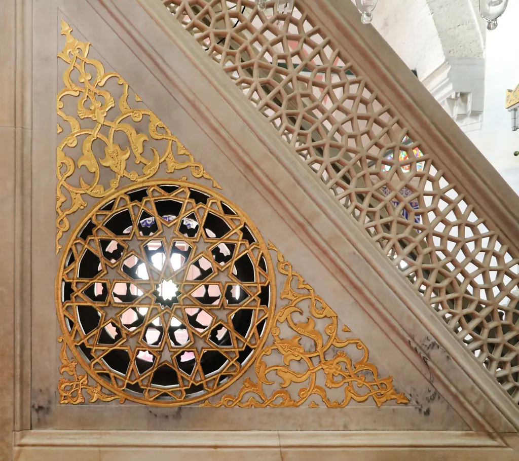 Kılıç Ali Paşa Camii'nin mermer minberi; yan aynada altın yaldızlı rumi süslemeler, yuvarlak geometrik şebeke ve merdiven korkuluğundaki oyma işçiliği.