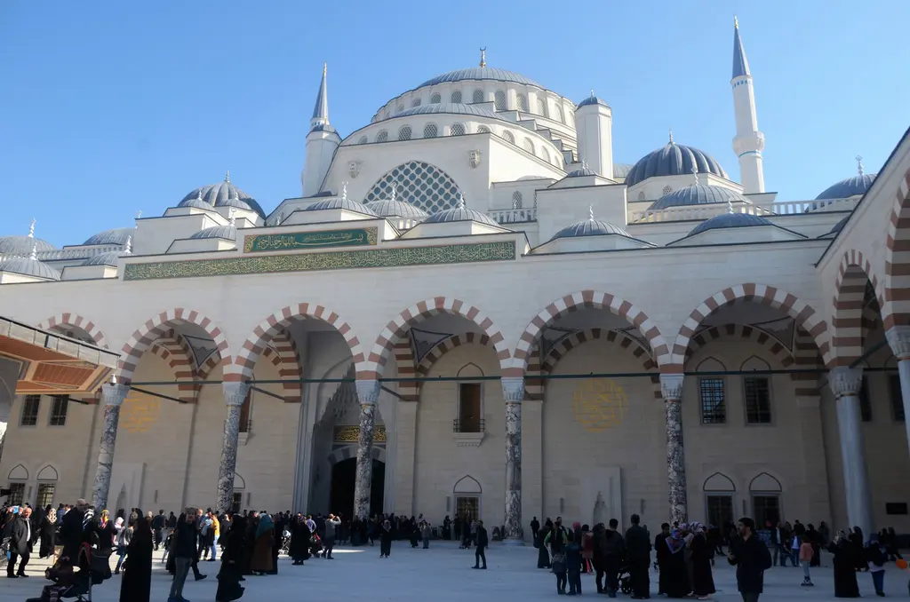 Büyük Çamlıca Camii'nin avlusu; revakların ardında yükselen ana kubbe, yarım kubbeler ve kalabalık ziyaretçiler.