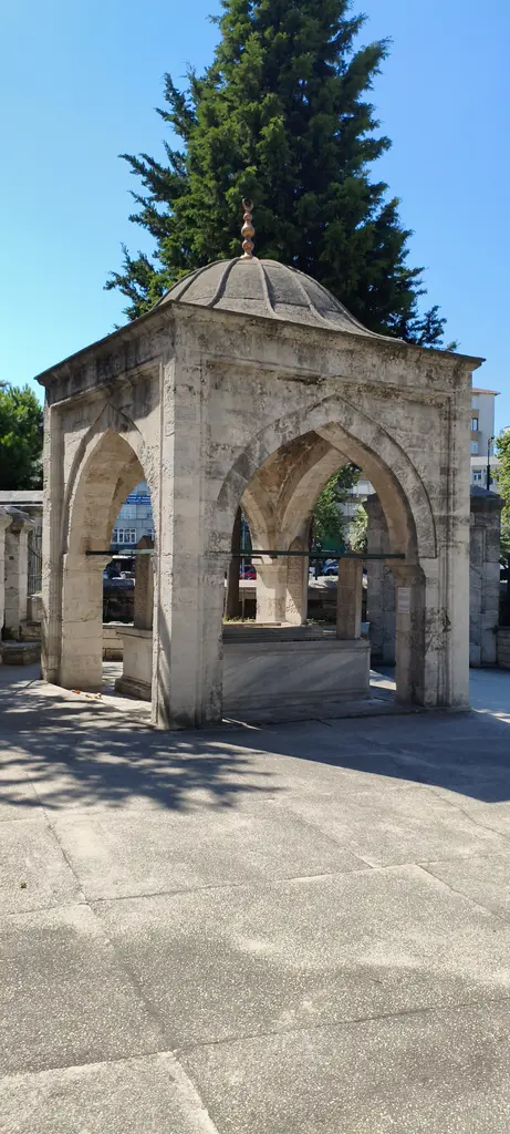 Murat Paşa Camii avlusunda Şirmerd Çavuş Türbesi; taş payeler üzerinde sivri kemerler, kurşun kaplı kubbe ve açık kenarlar.
